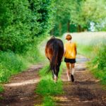 woman walking beside horse